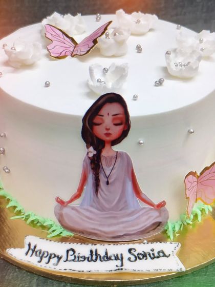 A serene yoga-themed cake with a pista flavor. This cake is decorated with a meditating figure and butterflies for a peaceful celebration.