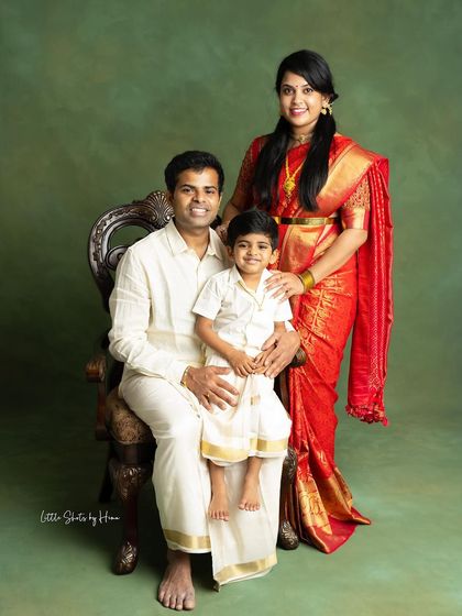 Another take on a classic family portrait, with the father seated. The family's coordinated traditional outfits and happy expressions make this a perfect keepsake.
