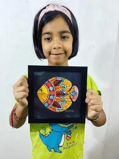 Another happy student from our kids' art camp with her framed Madhubani painting. The bright colors and bold patterns of this folk art style are perfect for young creators.