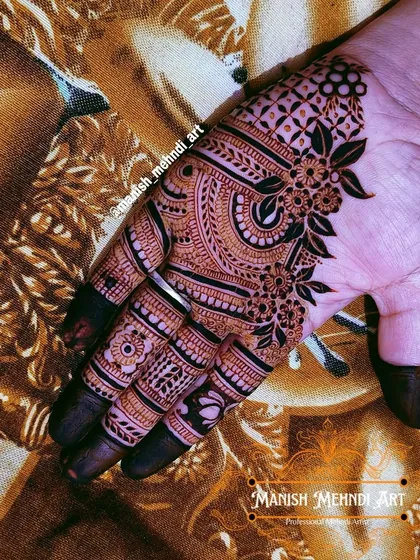 A classic back-hand design with a mix of floral and paisley motifs. The fingers are fully covered in henna, a traditional style that many brides love for its rich look.