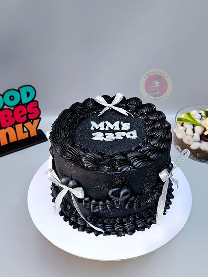 A striking black vintage cake with silver ribbons and glitter, made for a 23rd birthday.