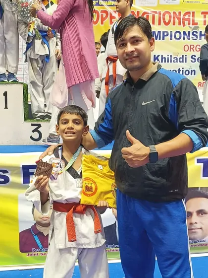 A young student with his bronze medal, happy with his performance at the national championship.