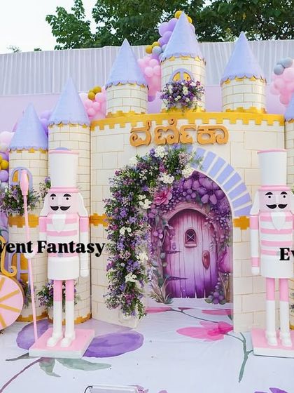 A whimsical scene from Varnnika's fairyland, featuring a large clock carriage and nutcracker props guarding the castle.