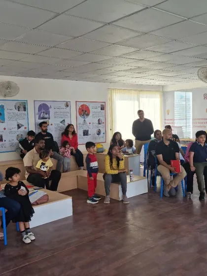 Parents and children listen intently during the "Out of the Box" workshop. I believe in creating learning experiences that involve the whole family.
