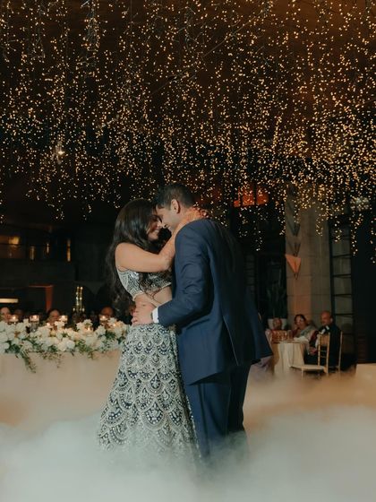 The couple's first dance, surrounded by low-lying fog and a shower of confetti. This magical shot captures the romance and fairytale quality of their reception.
