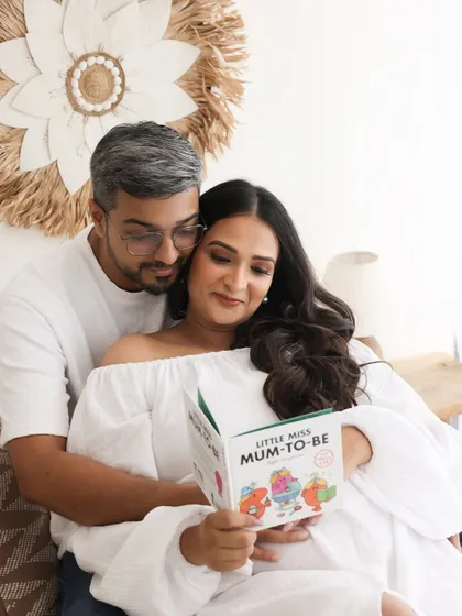 Preparing for their new role with love and a little bit of fun. Reading a 'Mum-to-be' book together is a sweet, playful moment that adds personality to their session.