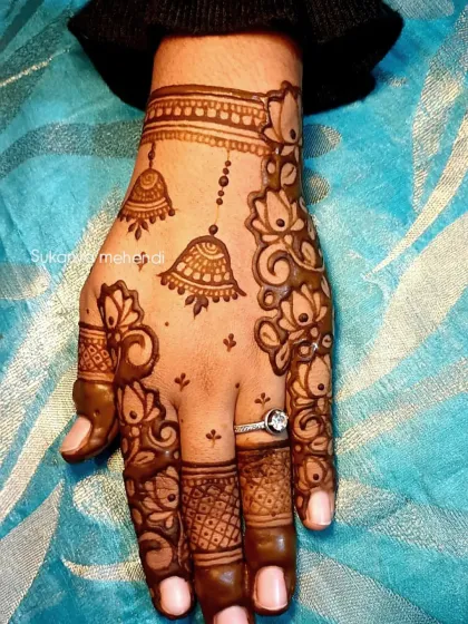 A delicate and minimalist design featuring hanging jhumka (earring) motifs. It's a modern and stylish choice for festivals like Karvachauth or for bridesmaids.