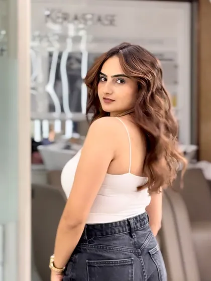 A beautiful shot of a finished caramel balayage. The soft waves perfectly showcase the seamless blend of colors and the healthy shine of the hair.