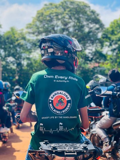 "Own Every Ride." A rider wearing our custom BMR T-shirt, surrounded by fellow bikers at a WMD event. This image embodies our spirit and our motto to "Grasp Life By The Handlebars."