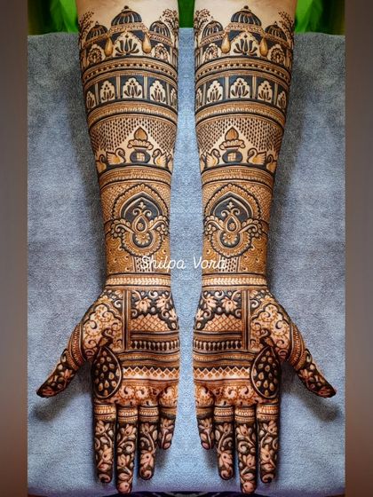 A full-arm bridal design with architectural elements and traditional motifs, creating a regal and timeless look.