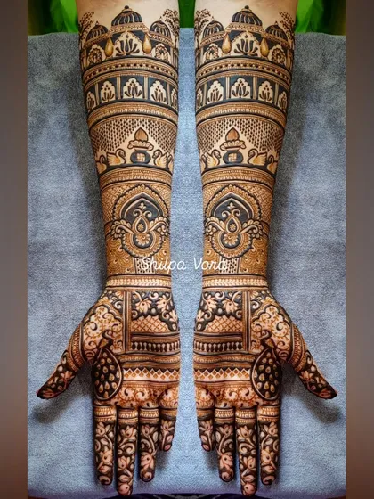 A full-arm bridal design with architectural elements and traditional motifs, creating a regal and timeless look.