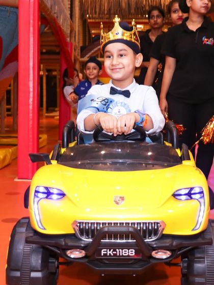 The birthday boy making his grand entrance. The smile on his face is the ultimate measure of a successful party.