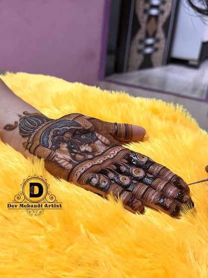 A close-up of a Karwa Chauth themed design being applied. The details in the figure work are what set our art apart.