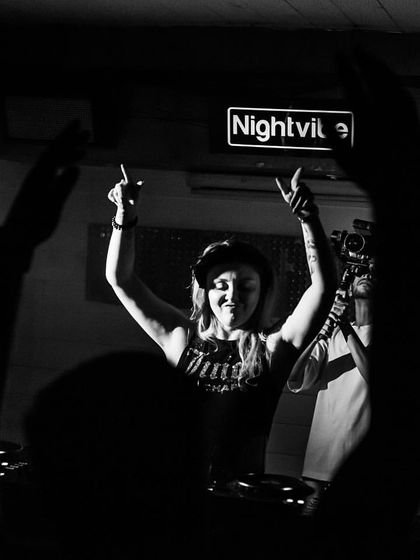 A black and white photo capturing a moment of celebration with the crowd, hands in the air. It has a timeless, classic party feel.