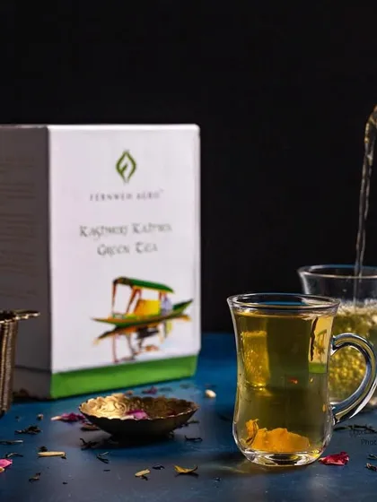 A dynamic pour shot of Kashmiri Kahwa tea. This image captures the flow and warmth of the beverage, making it feel alive and inviting.