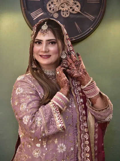 A happy, smiling photo of the engagement bride, adjusting her jewellery and looking absolutely beautiful.