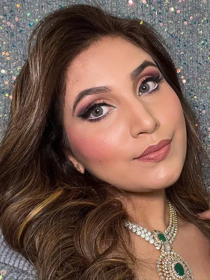 A detailed shot of the eye makeup, which features a classic winged liner and blended smokey shadow. This is paired with soft waves for a balanced look.