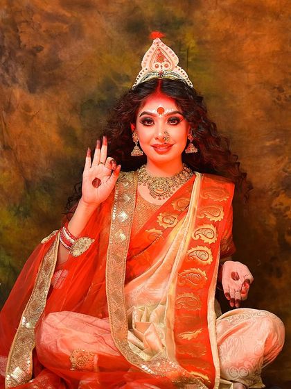 The model posing with a hand gesture of blessing, embodying the grace and power of the goddess.