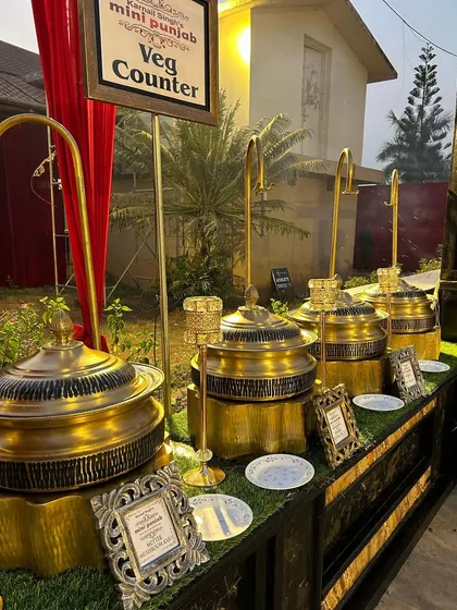 Our vegetarian counter setup, featuring ornate golden chafing dishes on a lush green turf base. We believe the presentation of the food should be as exquisite as its taste.