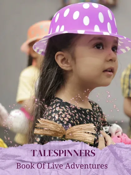 A young girl in a polka-dot hat, fully engaged in our "Talespinners: Book of Live Adventures" program.