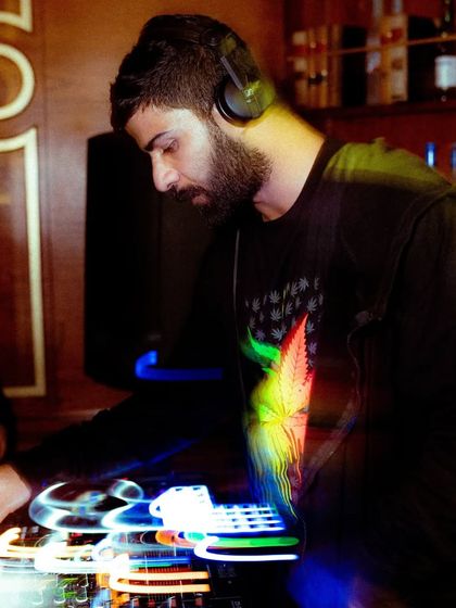 A long-exposure shot capturing the movement and energy at the DJ console. It's a blur of lights, sound, and motion.