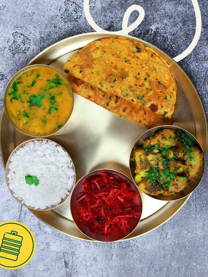 A colourful and balanced vegetarian thali with aloo sabzi, beetroot salad, dal, and methi thepla. It's a nutritious meal that doesn't compromise on taste.