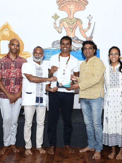 A graduate of the June sound healing course receives his certificate, surrounded by his teachers and peers.
