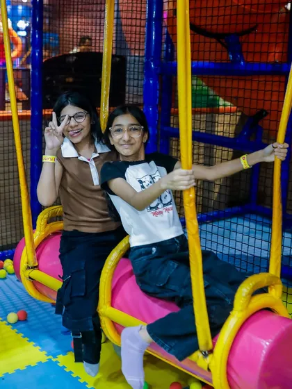 Best friends enjoying the swinging log ride together. It's a great spot for kids to team up and have fun during a party.