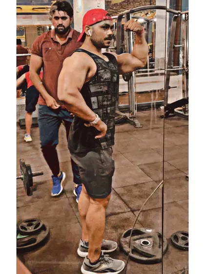 Posing in the mirror during a workout. I guide my clients to focus on the mind-muscle connection, which is enhanced by watching your muscles work.