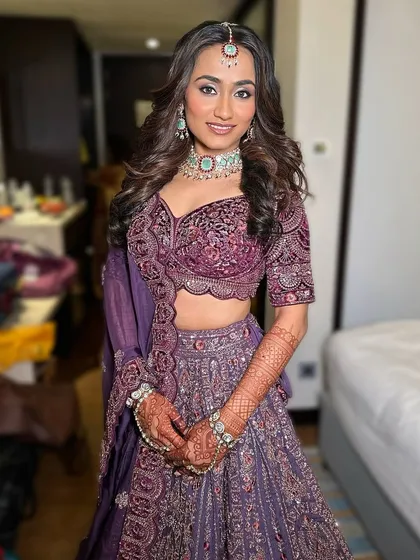 This bride is ready for her reception in a gorgeous purple lehenga. The mint green and zircon necklace adds a beautiful, unexpected pop of color and modern flair.