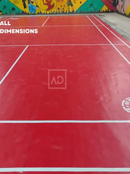 A completed badminton court with my red sports flooring and clear white line markings. The surface is non-slip and provides a consistent ball bounce.