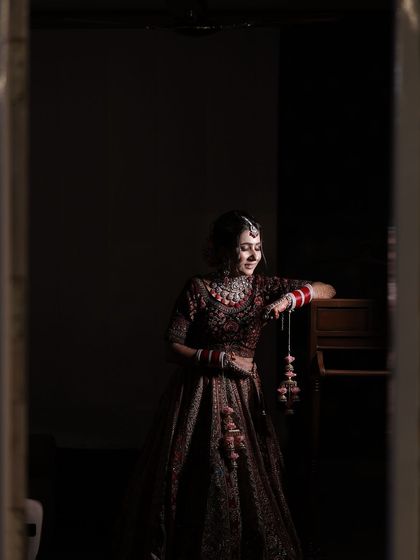 A quiet, reflective moment for the bride. The soft lighting enhances the gentle glow of her makeup.
