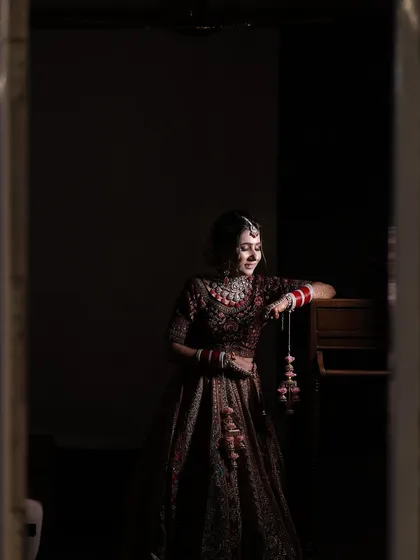 A quiet, reflective moment for the bride. The soft lighting enhances the gentle glow of her makeup.