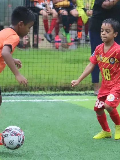 An intense one-on-one duel during a U9 match at the Grassroots Football Fiesta.