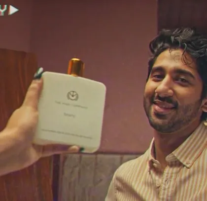 A product-focused shot from the film. Even when the product is the hero, the character's styling, like this casual striped shirt, helps to create the overall lifestyle context for the brand.