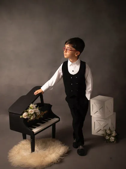 For this fifth birthday shoot, we went for a classic, dapper look. Using a miniature piano prop and dramatic lighting, we created a timeless portrait for this handsome young man.