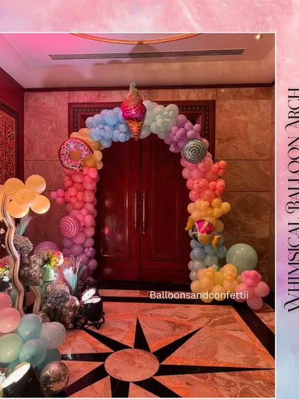 A whimsical balloon arch in pastel candy colors creates a magical entrance for the party guests.