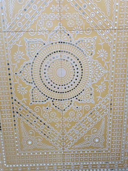 A Lippan art panel in a warm yellow, with a central mandala and detailed border work. These panels are ready to install for an instant feature wall.