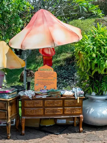 A whimsical welcome station for a Mehendi. Guests could pick up favors from vintage-style drawers, all set up under oversized, colorful mushroom installations.