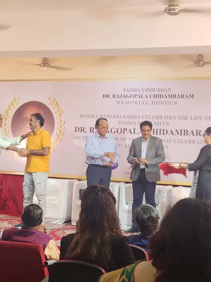 Shaking hands on stage after being presented with the memorial honor. These moments are a testament to the blessings of my gurus and the path of hard work.