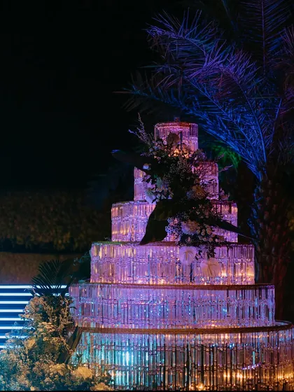 A multi-tiered crystal cake installation, illuminated from within, serves as a spectacular decor piece that perfectly complements the glamorous and dramatic Sangeet theme.