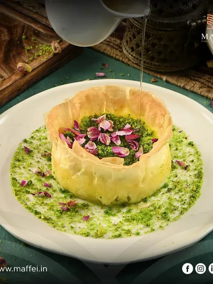 This is my creative take on a classic: the Baklava Cheesecake. It combines the creamy texture of New York cheesecake with the crisp, honeyed layers of traditional baklava, finished with a pistachio cream and delicate rose petals. It’s a unique fusion of flavors you will not find elsewhere.