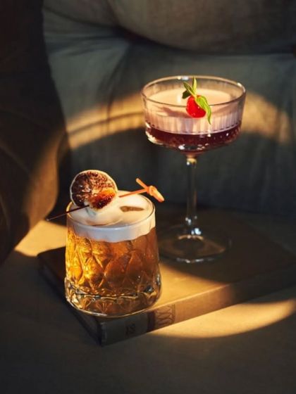 Two of our craft cocktails, catching the light. We focus on presentation as much as flavor, creating drinks that are a feast for the eyes.