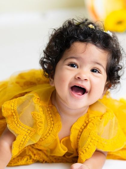 A big, happy laugh from this little girl in her yellow dress. This photo is pure sunshine and happiness, perfect for celebrating any day.