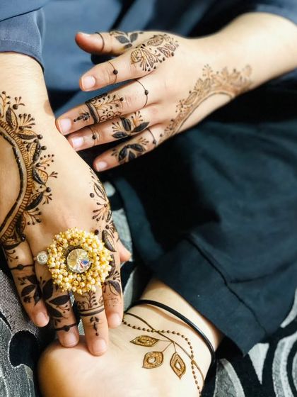 A chic and modern design combining hand and foot mehendi. The bold, leafy pattern on the back of the hand is complemented by a simple trail on the foot, creating a stylish look.