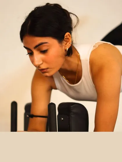 Pilates begins with focus. This close-up captures a client's concentration as she tunes into her breath and moves with purpose.