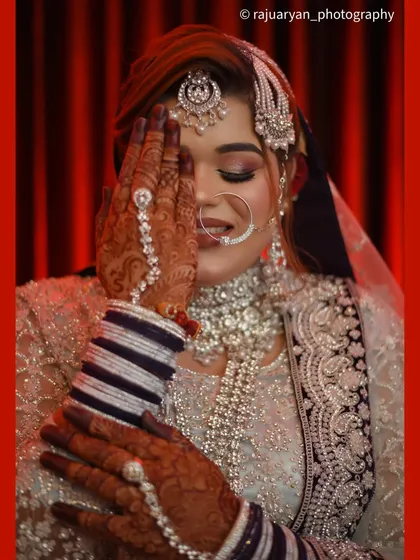 A close-up version of the 'haya' pose, bringing more focus to the bride's flawless makeup, nose ring, and the intricate details of her hand jewelry.