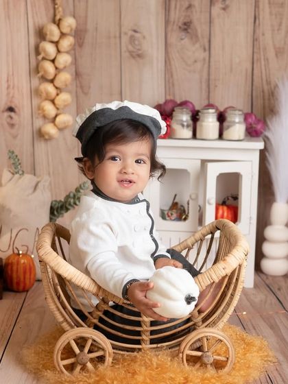 Absolute cuteness in a chef's uniform. This little boy is sitting in a cart, ready to go to the market for his ingredients. Themed sessions are all about telling a little story.