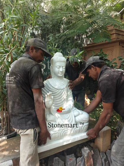 Three of our artisans carefully positioning the 3-foot Abhaya Mudra Buddha statue. This highlights the teamwork and effort involved in handling these heavy stone masterpieces.