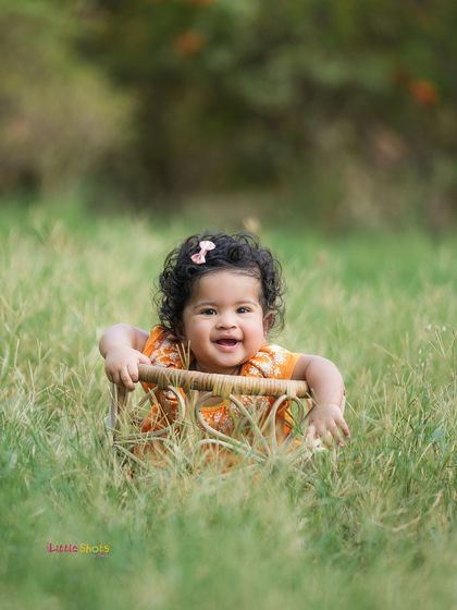 A candid moment of joy during an outdoor shoot. This baby's happy expression while sitting in a chair in the tall grass is priceless.